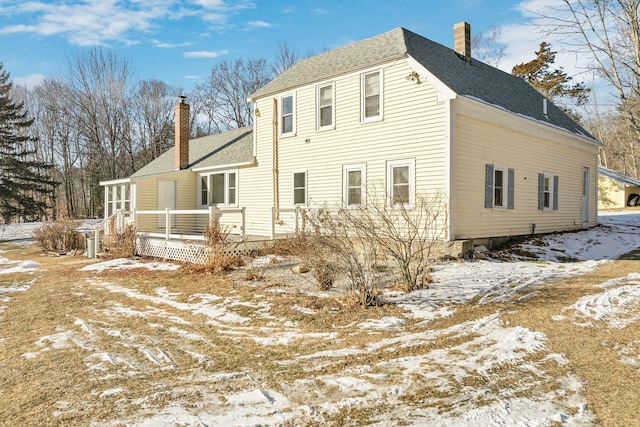 snow covered house with a wooden deck