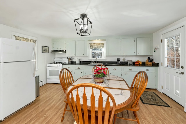 kitchen with light hardwood / wood-style floors, a notable chandelier, white appliances, a wealth of natural light, and sink