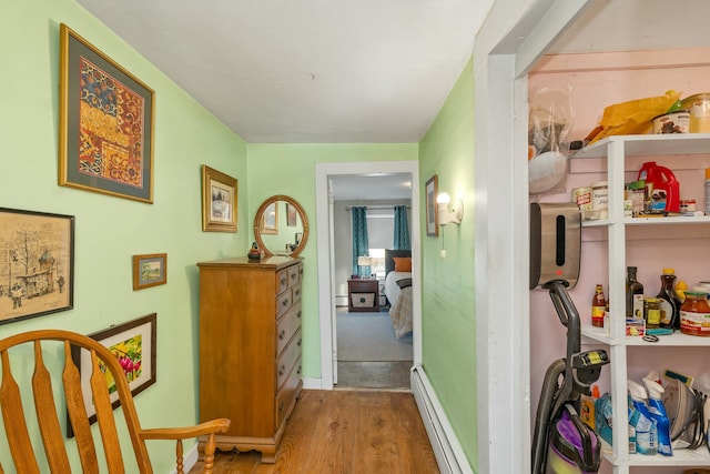 hallway with light hardwood / wood-style floors and a baseboard radiator