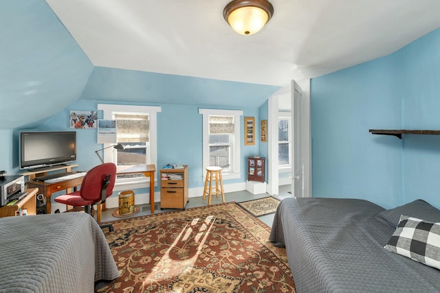 bedroom with lofted ceiling and connected bathroom