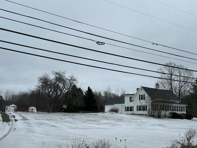 view of snowy exterior with a storage unit