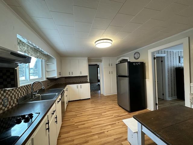 kitchen featuring light wood-type flooring, white cabinetry, appliances with stainless steel finishes, and tasteful backsplash