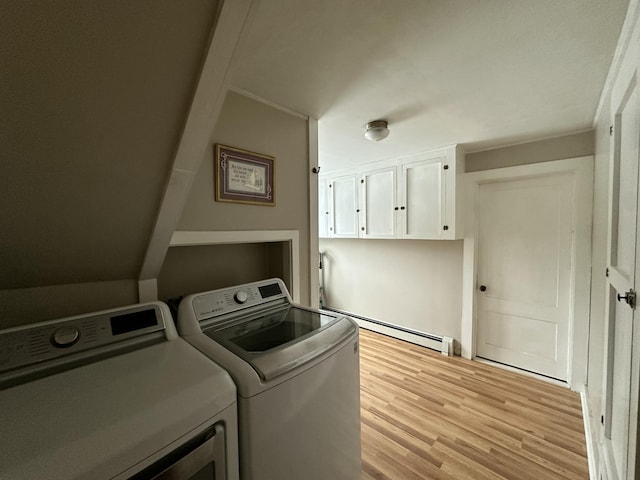 laundry area featuring light wood-type flooring, baseboard heating, and washing machine and clothes dryer