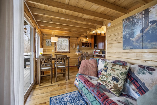 living room featuring beam ceiling, wood ceiling, hardwood / wood-style floors, and wooden walls