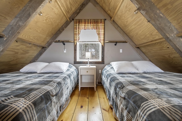 bedroom with lofted ceiling and wood-type flooring