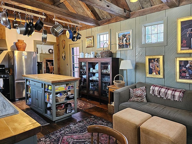 living room with vaulted ceiling with beams, wood walls, a wealth of natural light, and wood ceiling