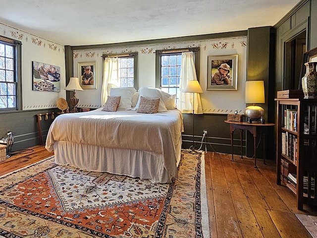 bedroom featuring multiple windows and hardwood / wood-style flooring