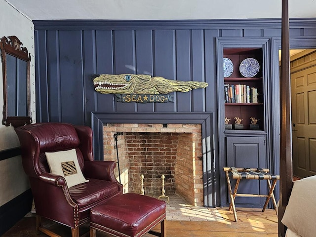 sitting room with built in features and hardwood / wood-style floors