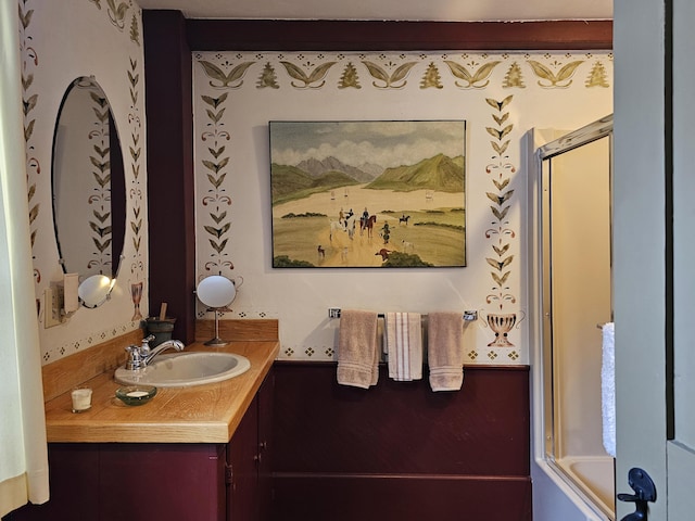 bathroom with vanity and enclosed tub / shower combo