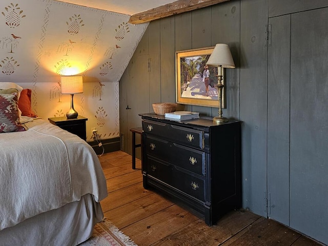 bedroom featuring a closet, lofted ceiling with beams, and hardwood / wood-style floors