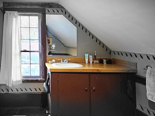 bathroom with lofted ceiling and vanity