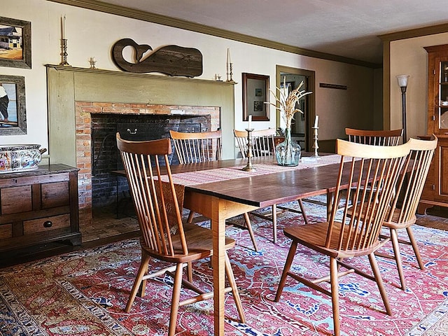 dining area featuring a brick fireplace and crown molding