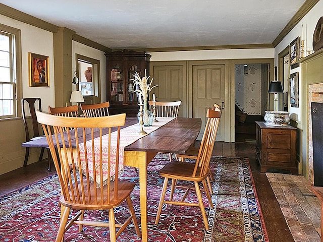 dining room with dark hardwood / wood-style flooring and crown molding