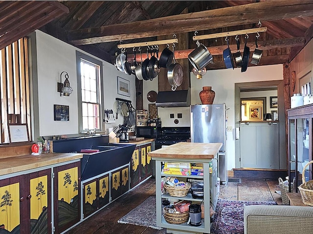 kitchen featuring stainless steel refrigerator, butcher block countertops, and lofted ceiling with beams