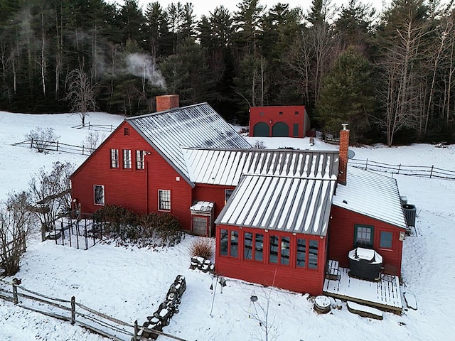 exterior space with a standing seam roof, metal roof, and a chimney