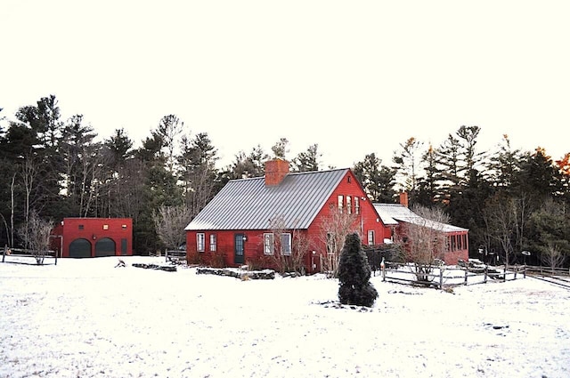 view of snowy exterior with an outbuilding and a garage