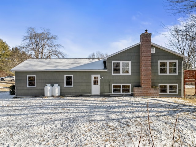 view of snow covered rear of property