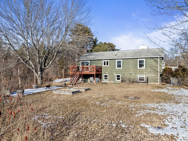 snow covered house featuring a wooden deck