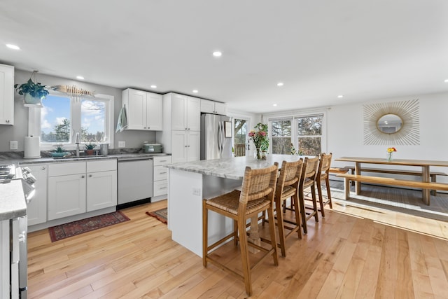 kitchen with stainless steel appliances, light hardwood / wood-style flooring, white cabinets, and sink