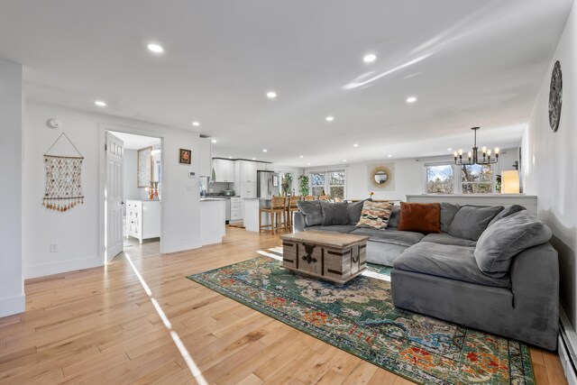 living room featuring light hardwood / wood-style floors and an inviting chandelier