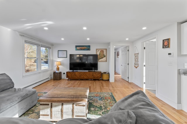 living room featuring a baseboard heating unit and light hardwood / wood-style floors