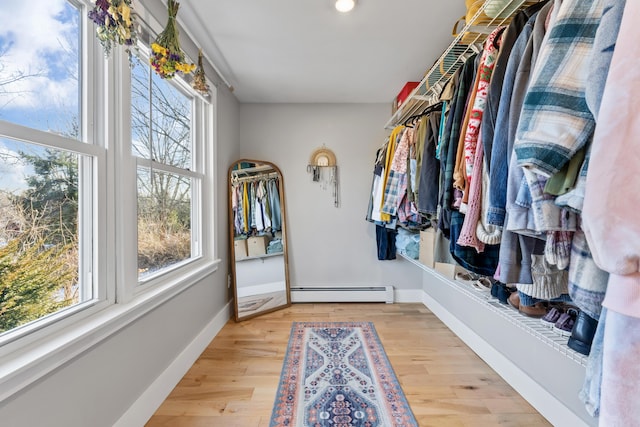 walk in closet with baseboard heating and light hardwood / wood-style floors