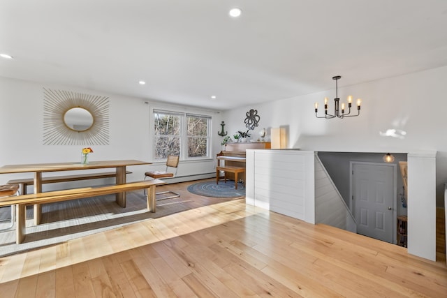 interior space featuring a baseboard heating unit, a chandelier, and light hardwood / wood-style flooring