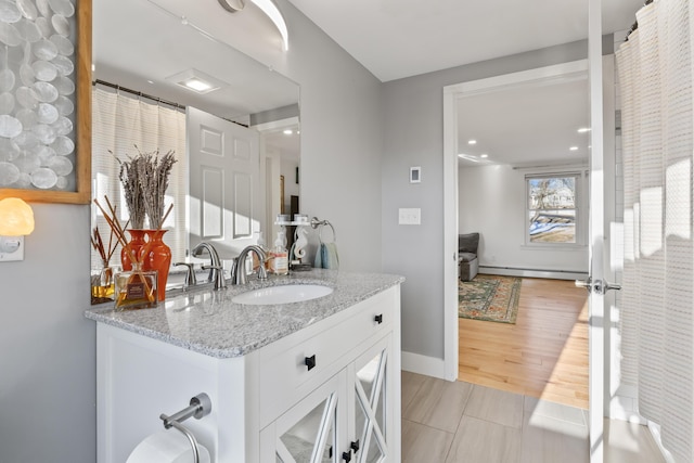 bathroom featuring tile patterned flooring, vanity, and a baseboard radiator