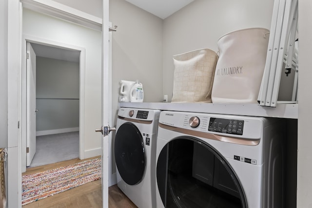 washroom with wood-type flooring and independent washer and dryer