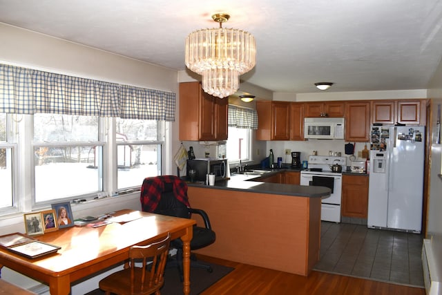 kitchen with white appliances, an inviting chandelier, sink, dark hardwood / wood-style floors, and decorative light fixtures