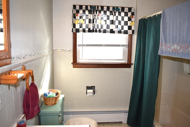 bathroom featuring toilet, shower / bath combination with curtain, baseboard heating, and tile walls