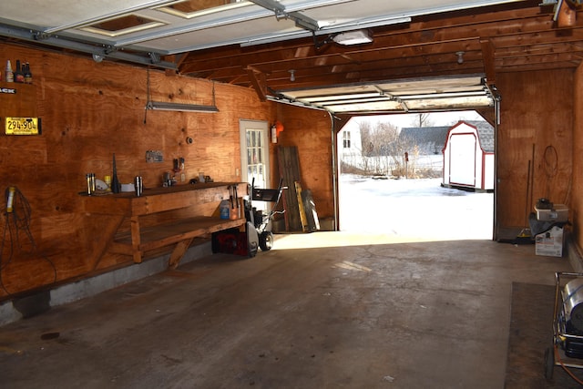 garage with a workshop area and wooden walls