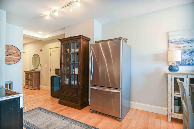 kitchen featuring stainless steel fridge and hardwood / wood-style flooring