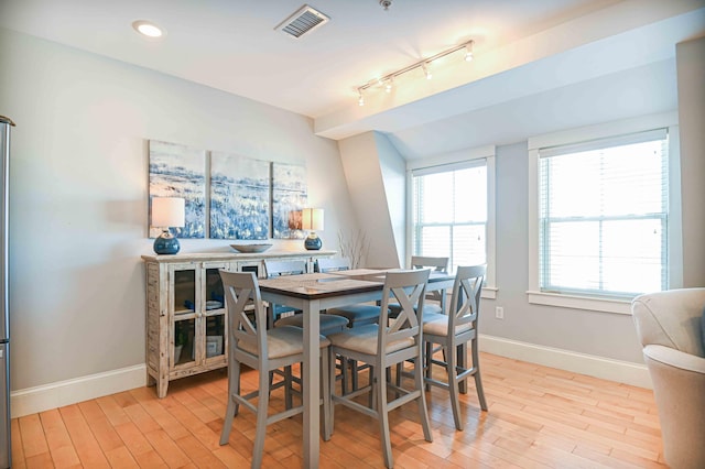 dining space featuring light wood-type flooring and track lighting