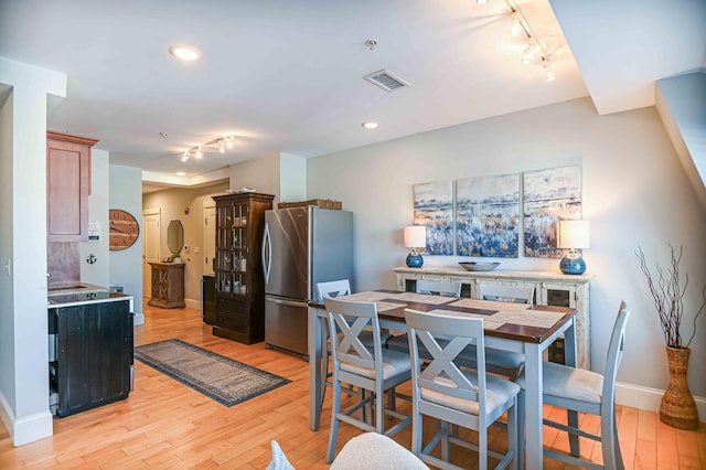 kitchen featuring stainless steel fridge, rail lighting, light hardwood / wood-style flooring, and light brown cabinetry