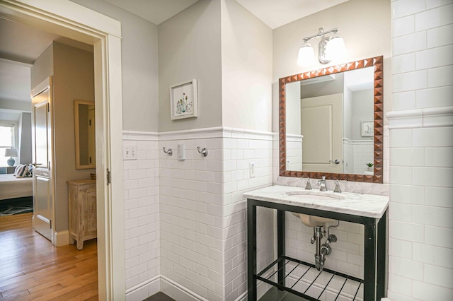 bathroom featuring sink, tile walls, and hardwood / wood-style flooring