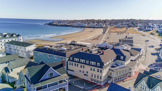 birds eye view of property with a water view and a beach view