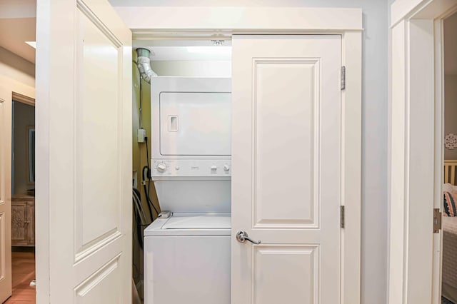 clothes washing area featuring stacked washer and dryer