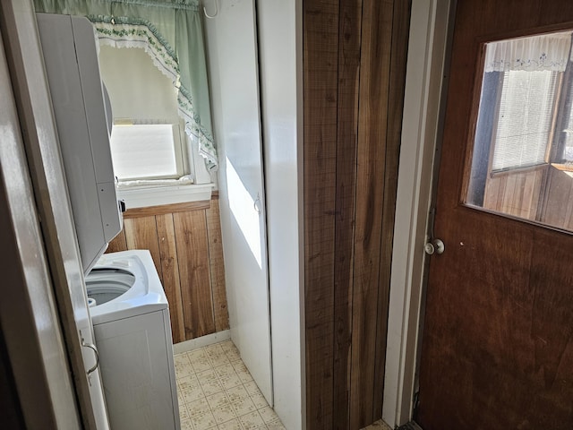 laundry room with washer / dryer, wood walls, and a wealth of natural light