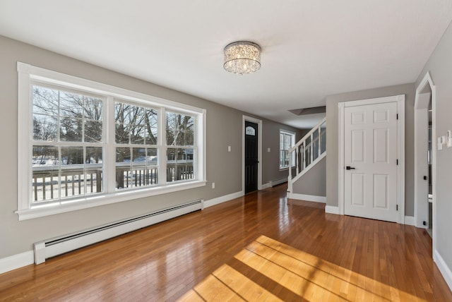 foyer featuring an inviting chandelier, a baseboard radiator, and hardwood / wood-style floors