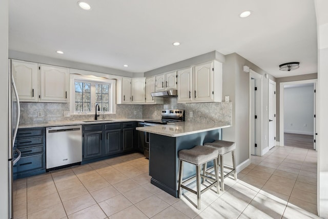 kitchen with white cabinetry, appliances with stainless steel finishes, sink, and light tile patterned floors