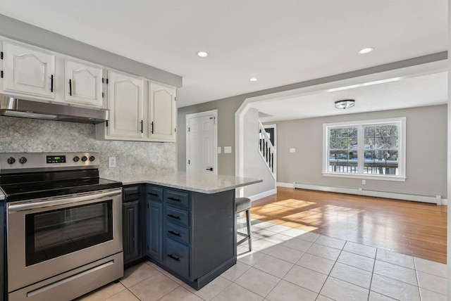 kitchen featuring light tile patterned floors, stainless steel electric range, white cabinetry, a baseboard radiator, and kitchen peninsula