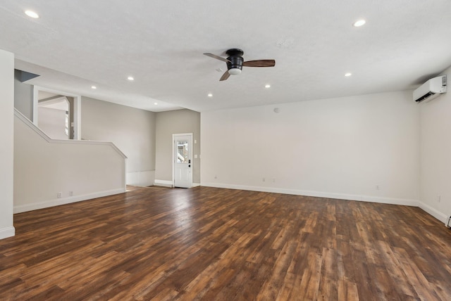 empty room with ceiling fan, dark hardwood / wood-style floors, and a wall unit AC