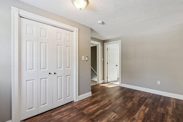 unfurnished bedroom with dark hardwood / wood-style floors, a closet, and a textured ceiling