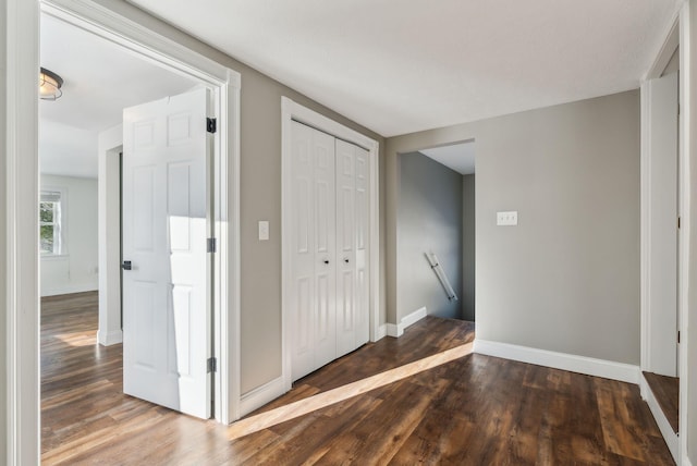 corridor with dark hardwood / wood-style flooring