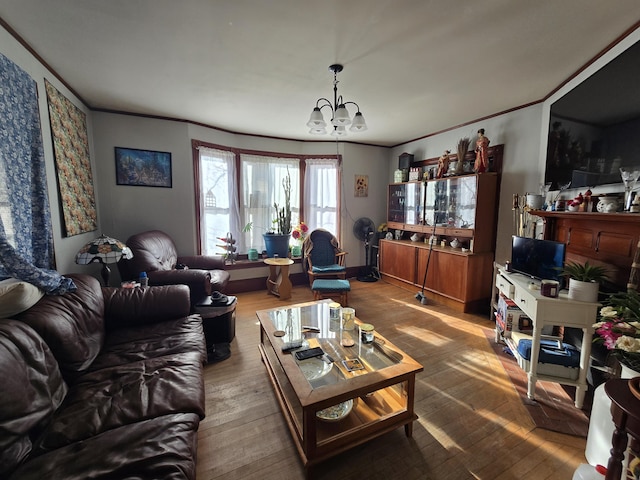 living room featuring hardwood / wood-style floors, ornamental molding, and a notable chandelier