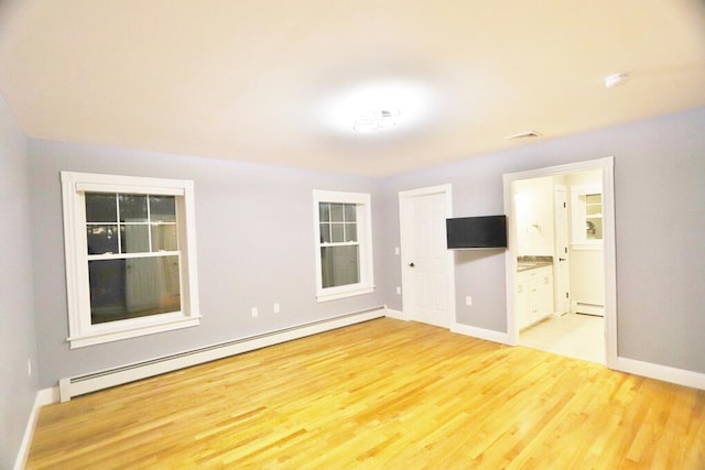 spare room with a baseboard radiator and light hardwood / wood-style floors