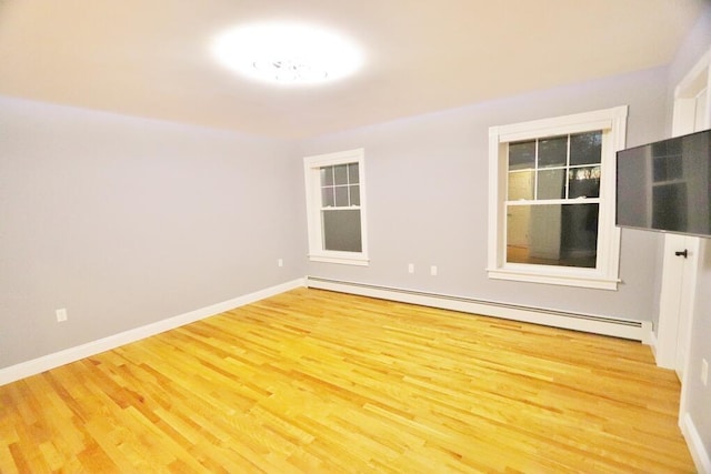 unfurnished room with wood-type flooring and a baseboard radiator