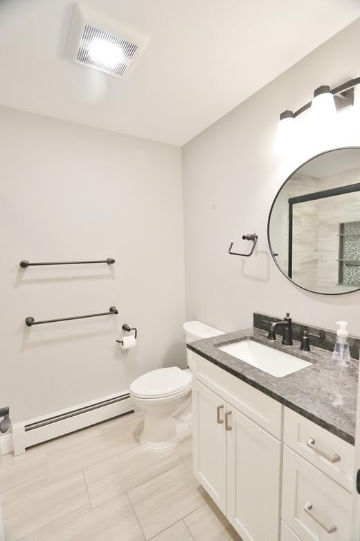 bathroom featuring vanity, tile patterned flooring, toilet, and baseboard heating