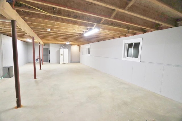 basement with white refrigerator with ice dispenser